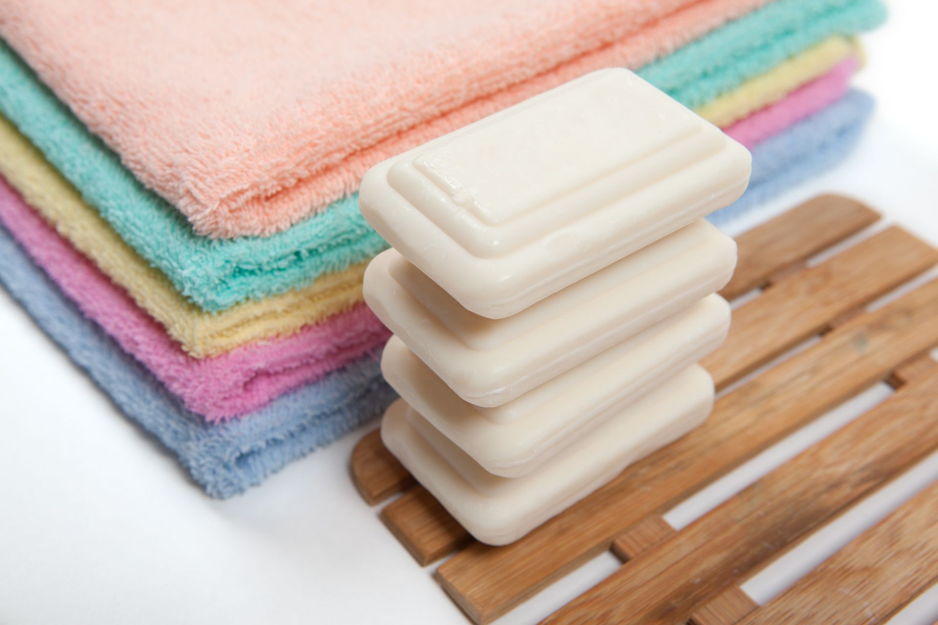 Colorful bath towels stacked and soap isolated on white background